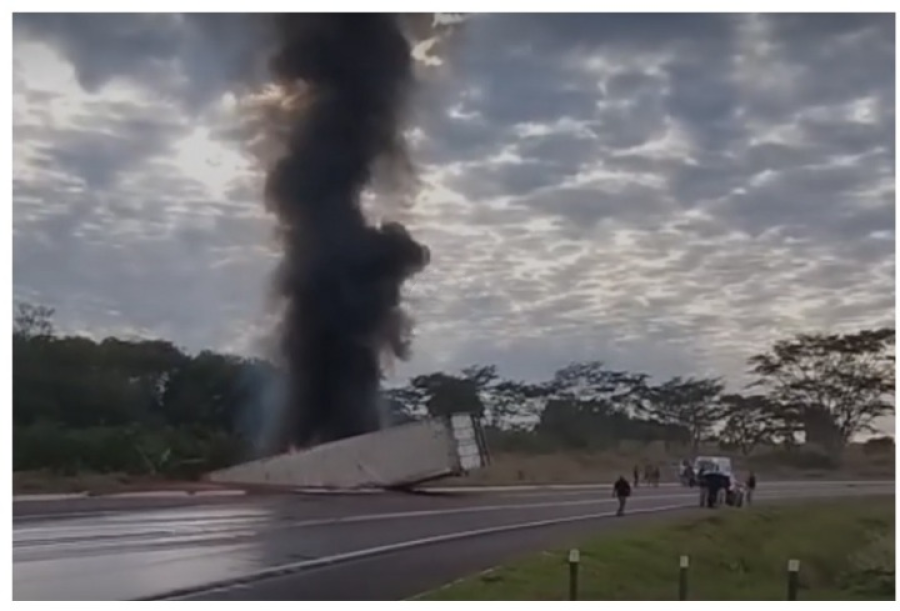 Carreta tomba, pega fogo e deixa motorista preso.